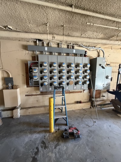 Multi-meter equipment with overhead conduit in a Van Nuys electrical room during installation.